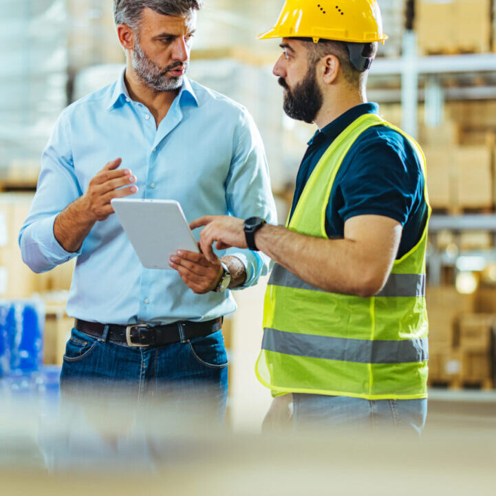 Manager and worker reviewing inventory data